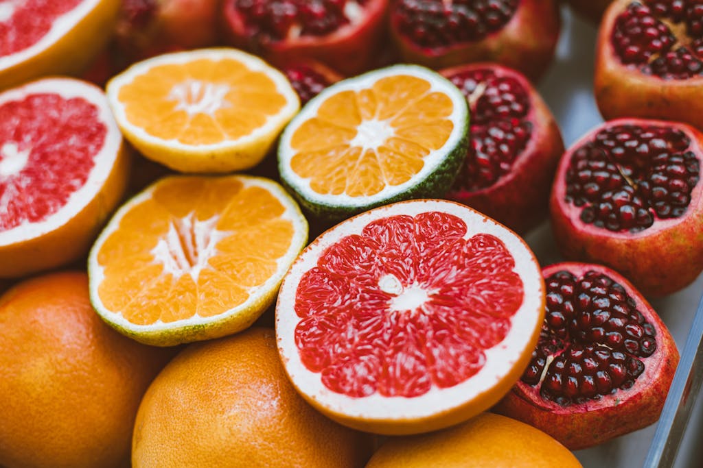 Fresh Cut in Half Oranges, Pomegranates and Grapefruits